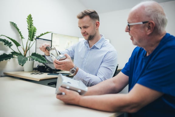 Zwei Mitarbeiter bei der technischen Begutachtung von Rollenkomponenten im Büro – Rollen und Räder Produktentwicklung bei Schwalb